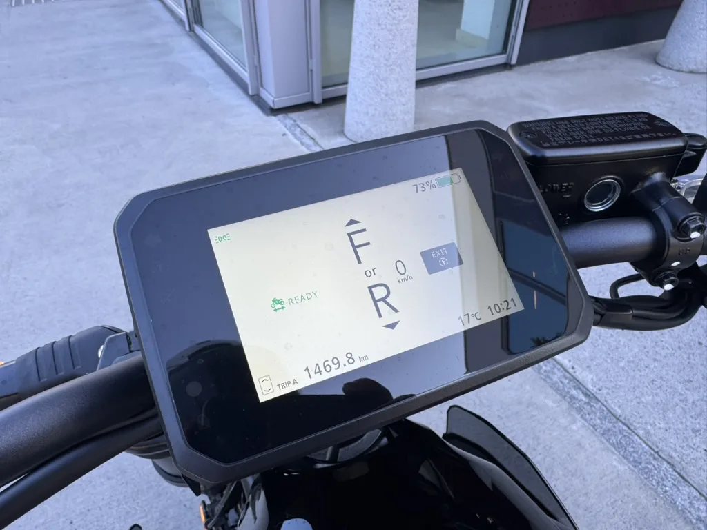 Nærbilde av den 5 tommer store TFT-skjermen på Honda WN7, som viser kjøremodus, 73 % batterinivå, 0 km/t, 1469,8 km kjørt og klokken 10:21