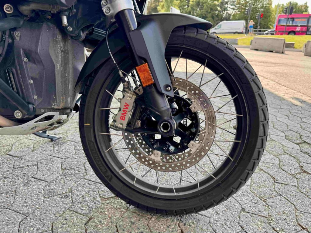 Nærbilde av eikerhjul foran på BMW R 1300 GS Adventure, med BMW-bremskalipper og terrengdekk