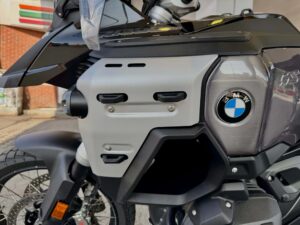Nærbilde av den store 30-liters tanken og festepunktene på BMW R 1300 GS Adventure, med BMW-logo og eikerhjul synlig