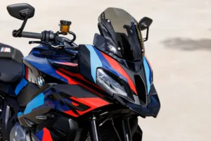 BMW M 1000 XR sett forfra med M-farger i blått, rødt og sort, røykfarget vindskjerm og karbondetaljer. Beepi.no / Bikelifenorge.no