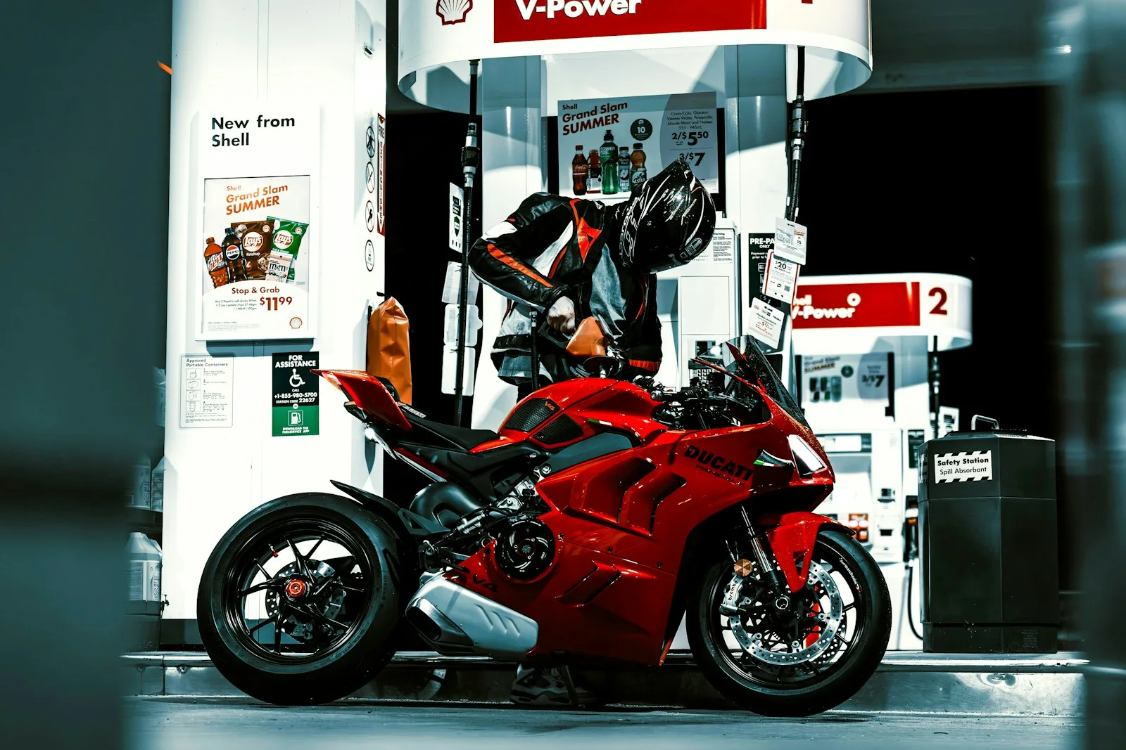A red motorcycle parked in front of a gas station